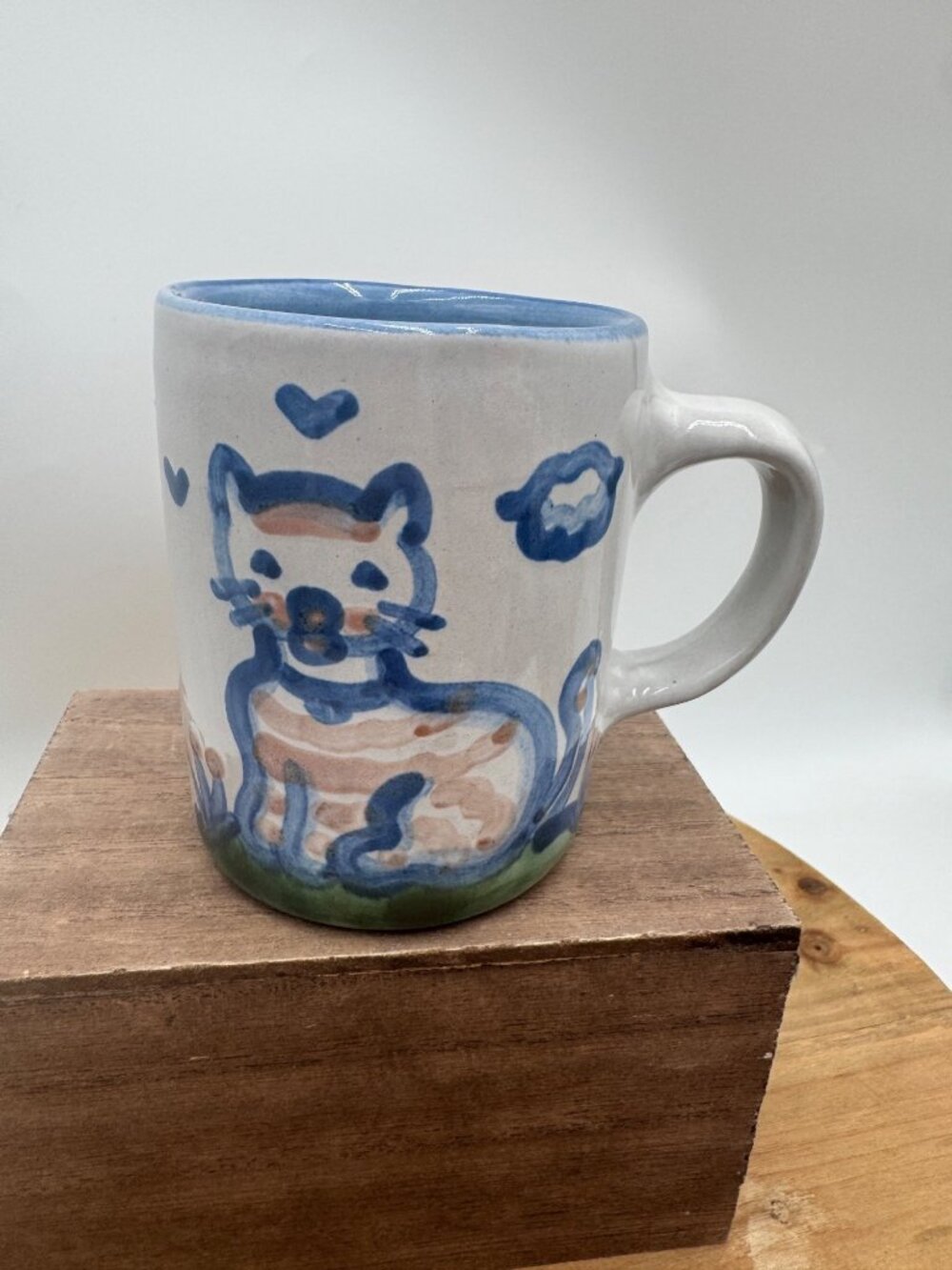 vintage M.A. Hadley pottery mug features a hand-painted blue cat The end on insi